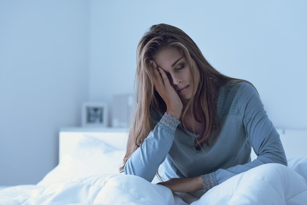 person in bed with headache wondering exactly what is drug detox