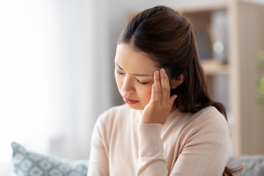 person struggling with mild headache as one of nad supplement side effects